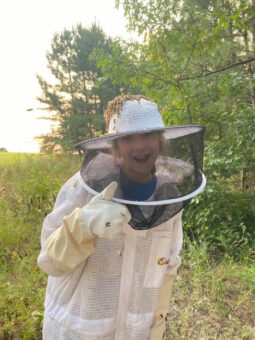 Girl wearing bee protection outfit giving thumbs up
