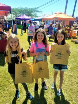 3 young girls holding farmers markets bags